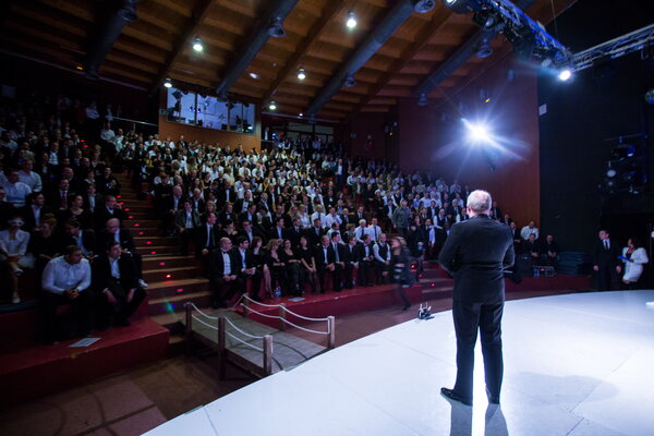 Kick-off USU Mallorca, Ein Redner steht auf der Bühne vor einem großen Publikum in einem festlichen Saal