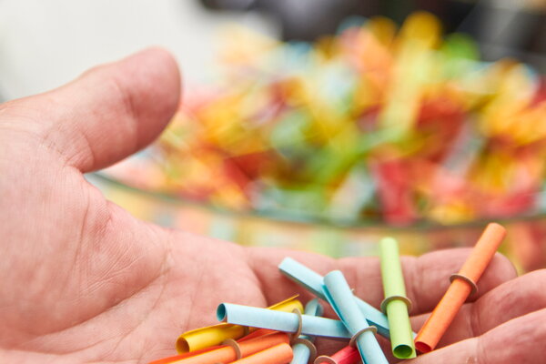 Kongress & Sommerfest Wolters Kluwer Scala, eine Hand hält bunte Lose, im Hintergrund eine Schüssel mit weiteren bunten Losen
