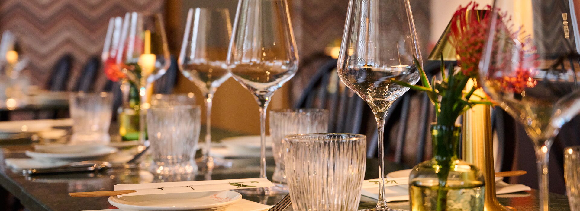 Müller-Live-Kommunikation Tischdekoration mit Gläsern, Besteck und Blumenarrangements für ein stilvolles Dinner-Erlebnis