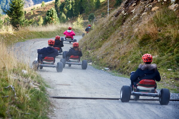 Incentive Sölden Personen fahren mit Mountaincarts auf einem Schotterweg bergab, Helme tragen