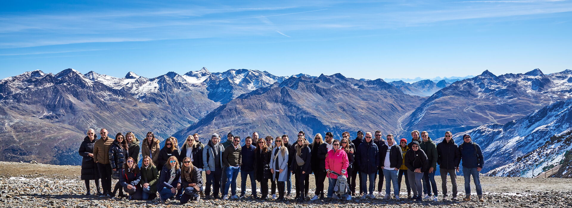 Incentive Sölden eine große Gruppe von Menschen posiert vor einer beeindruckenden Berglandschaft mit schneebedeckten Gipfeln