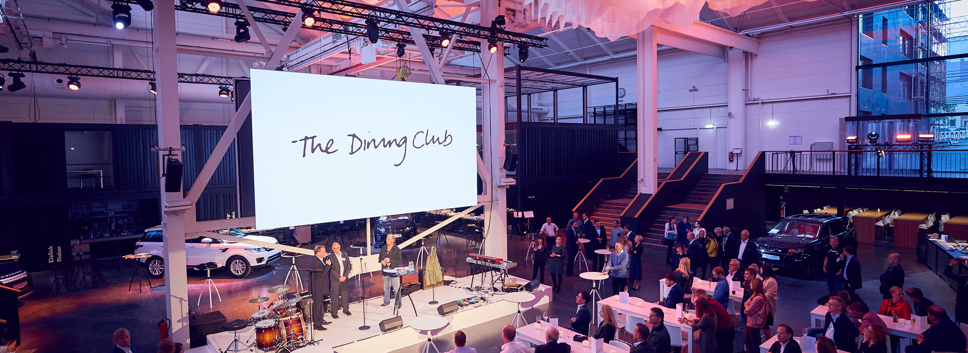 The Dining Club urbanharbor Ludwigsburg im speisewerk beim Empfang mit Rede auf der Bühne und Publikum