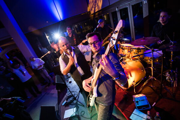 Kick-off USU Mallorca eine Live-Band spielt auf einer Bühne, mit einem Bassisten und einem Sänger