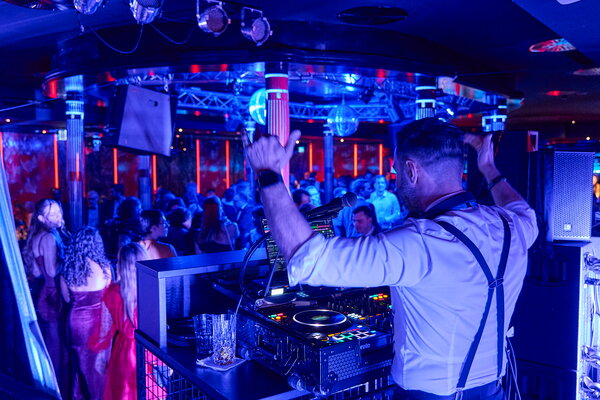 USU SPRING UP! in Willingen Nahaufnahme eines DJs der mit dem tanzenden Publikum auf der Tanzfläche feiert
