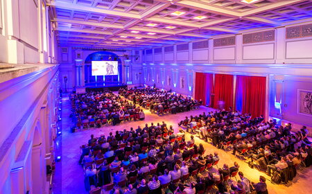 Kick-off USU Mallorca eine große Menschenmenge sitzt in einem beleuchteten Saal während einer Veranstaltung mit Präsentation