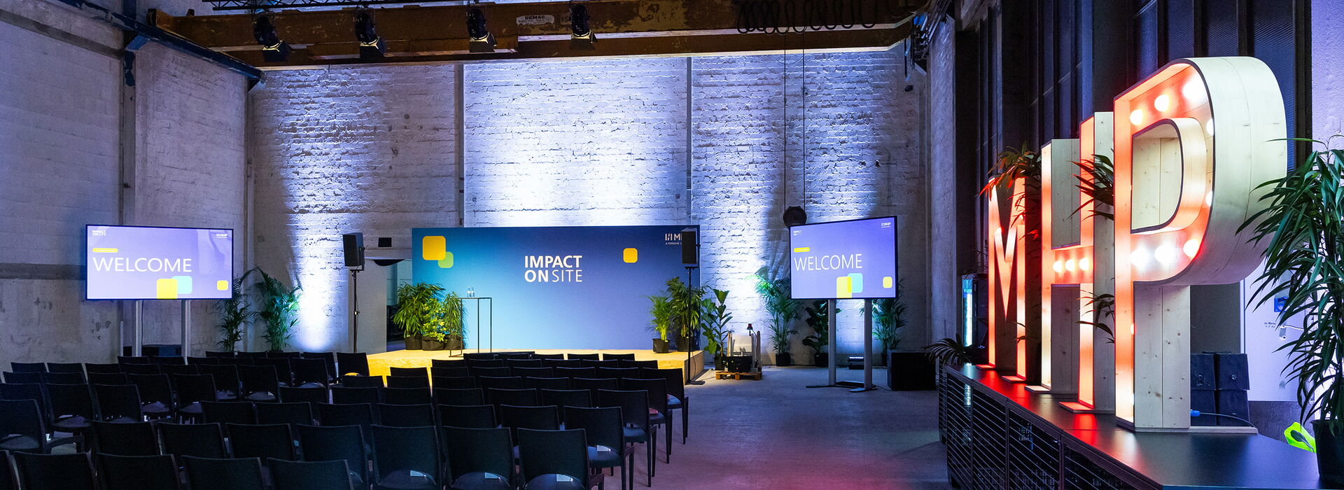 Tagung MHP Impact Onsite in der alten Härterei im urbanharbor Ludwigburg mit Reihenbestuhlung, Bühne und MHP Buchstaben