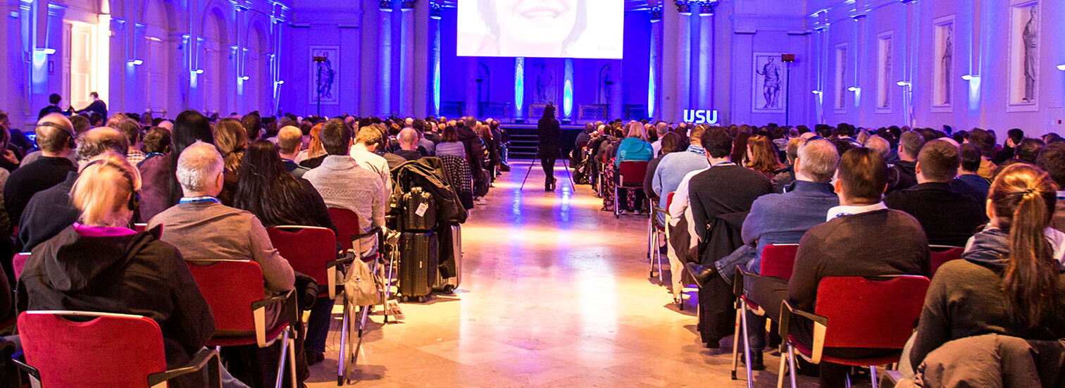 Kick-off USU Mallorca eine Menschenmenge sitzt in einem hell erleuchteten Saal während einer Präsentation mit LED Bildschirm