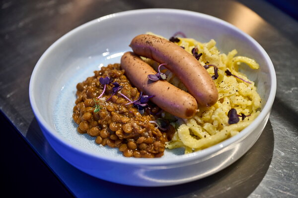 IHK Jahresempfang urbanharbor Ludwigsburg Ein Teller mit würzigen Linsen, Wiener Würsten und einer Portion Spätzle