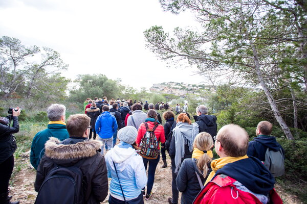Kick-off USU Mallorca, eine Gruppe von Menschen wandert auf einem malerischen Pfad an der Küste durch die Natur mit Bäumen