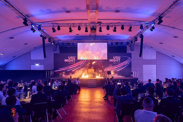 USU SPRING UP! in Willingen Blick auf die Bühne während einer Feuershow bei der "USU NIGHT 2025", mit Gästen im Publikum